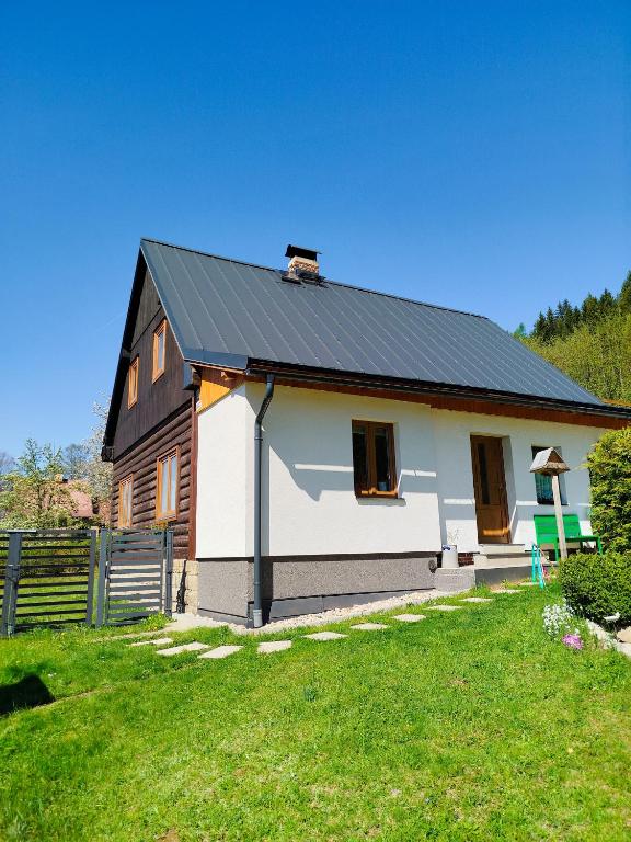a white house with a black roof at Chalupa Emma in Tanvald
