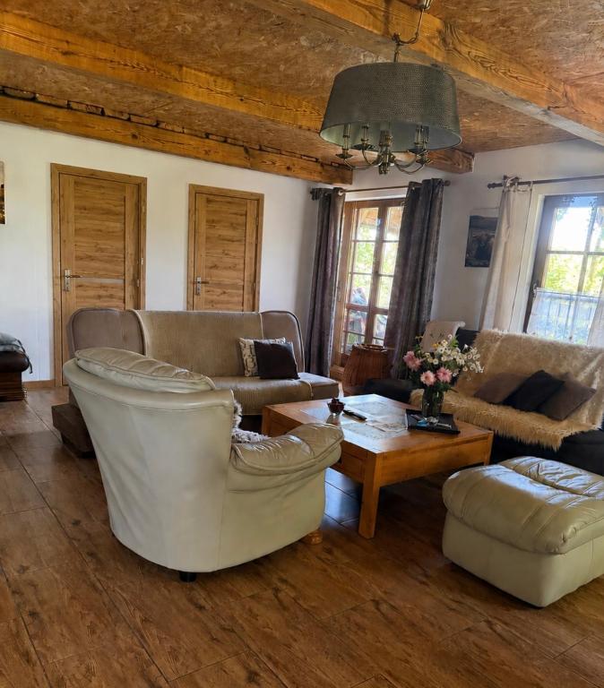 a living room with two couches and a table at Dom nad rzeką in Neple