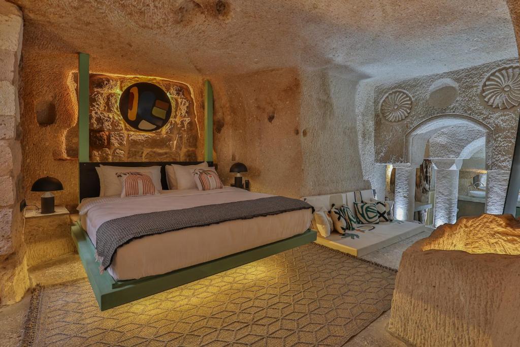 a bedroom with a bed in a stone room at Eka Cave Maison Authentic Cave Boutique Hotel in Cappadocia Village in Nevşehir