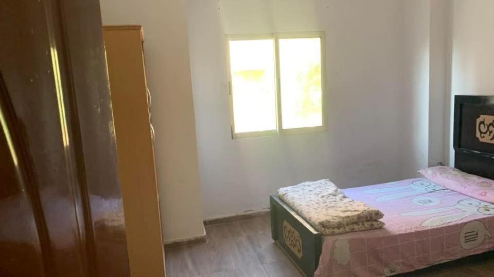 a small bedroom with a bed and a window at Soukaina home in Sintrīs
