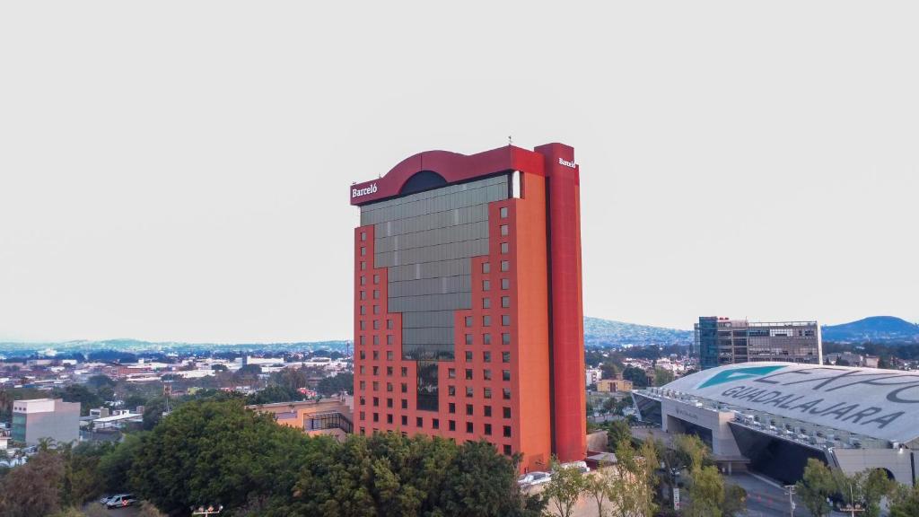 a tall red building with a city in the background at Barcelo Guadalajara in Guadalajara