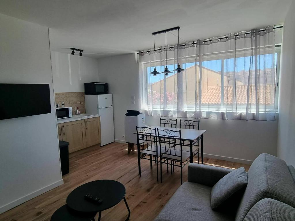 a living room with a couch and a table with chairs at Palma 2 in Port-la-Nouvelle