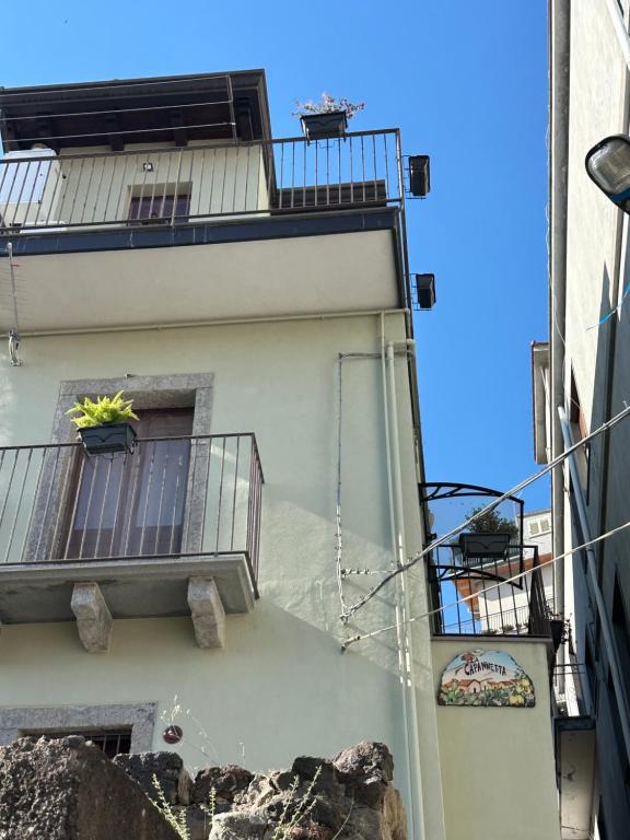 a building with a balcony with a plant on it at La capannetta house in Castiglione di Sicilia