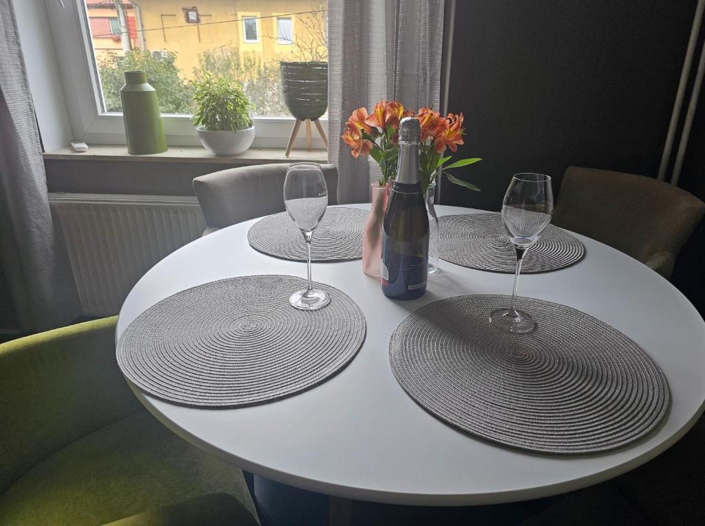a white table with two glasses and a bottle of wine at Apartma 2 in Pekre