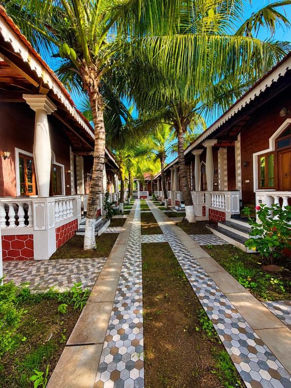 a row of houses with palm trees in front of them at Baga Beach Palm Cottage in Calangute