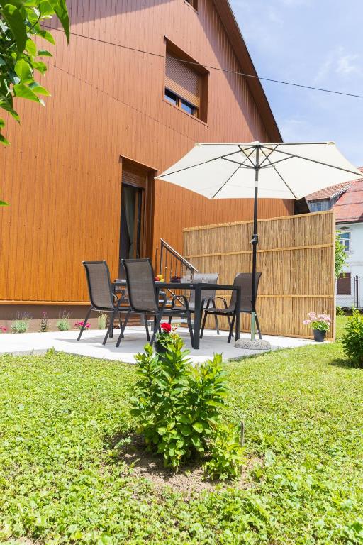 a patio with a table and an umbrella at Apartman ''Kod bake'' Delnice biker-friendly in Delnice
