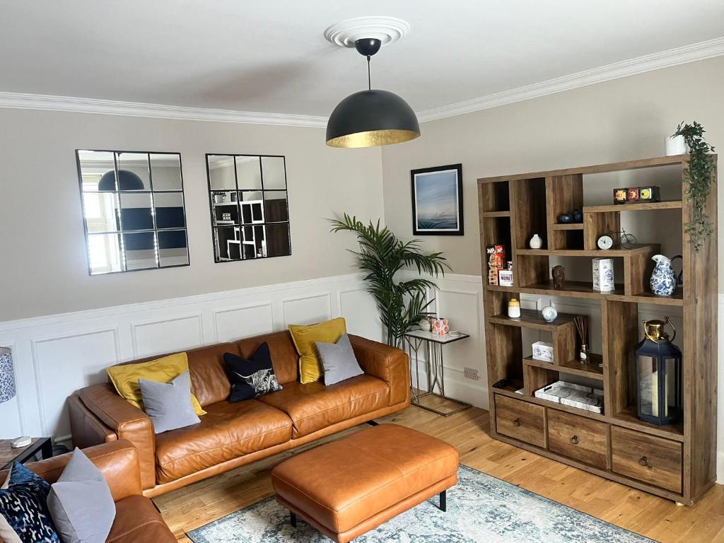 a living room with a brown leather couch at The townhouse in Stornoway
