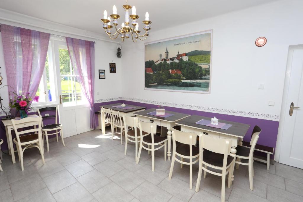 a dining room with tables and chairs and a painting on the wall at Vila Sazava in Sázava