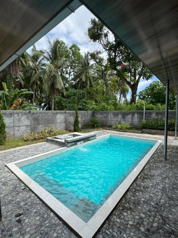 an empty swimming pool in a house with a large window at Villa Droom Nest Manado in Manado