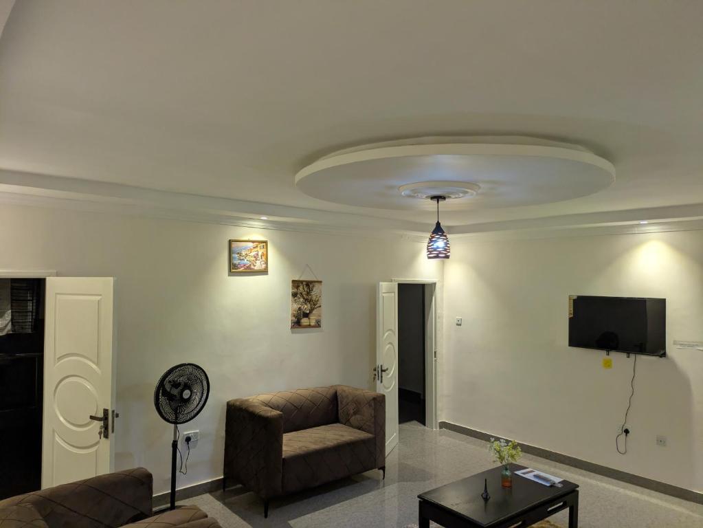 a living room with a couch and a flat screen tv at Maneya Apartments in Kabwe