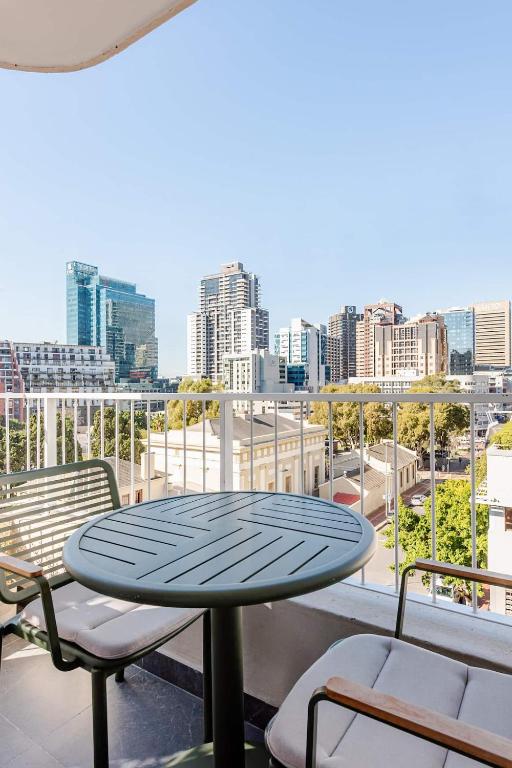 a table and chairs on a balcony with a city skyline at The Lookout in Cape Town