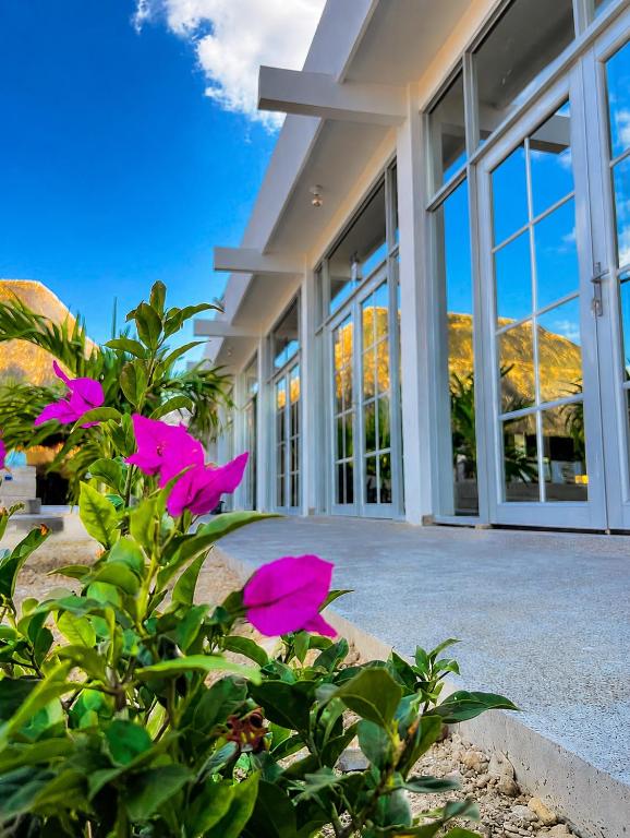 a building with pink flowers in front of it at CASTLE WHITE by MONARCA in Ríohacha