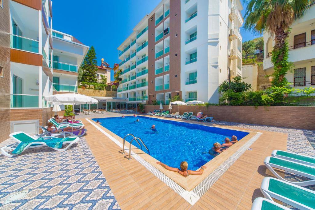 a swimming pool with people in a hotel at Kleopatra Atlas Hotel - Adults Only in Alanya