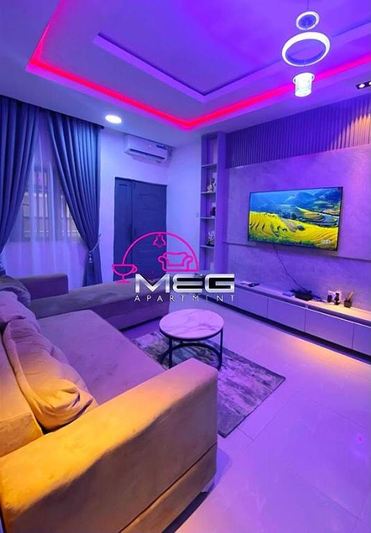 a living room with a couch and a tv at Meg Apartment in Asipa