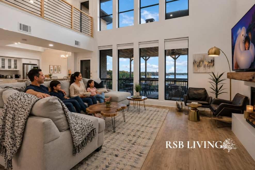 a family sitting on a couch in a living room at Lakefront Luxe 6BR 4,5BA Holiday Home with Pool & Hot Tub in Rowlett