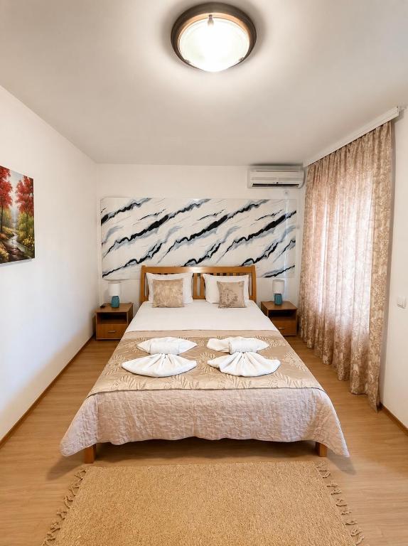 a bedroom with a bed with two towels on it at M Apartments 2 in Bar