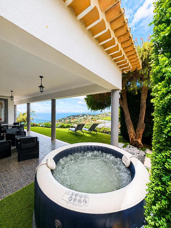 a hot tub in the backyard of a house at Casa Conduto in Ponta do Sol