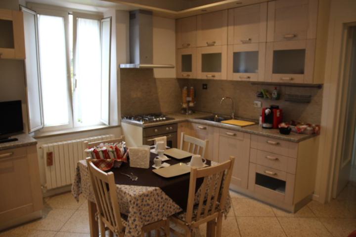 eine Küche mit einem Tisch mit Stühlen und einem Herd in der Unterkunft Sotto il Borgo Apartments in Iesi