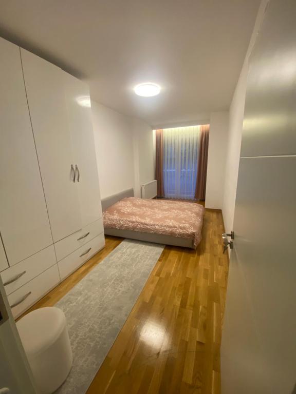 a small bedroom with a bed and a closet at AJ Apartments in Kosovo Polje