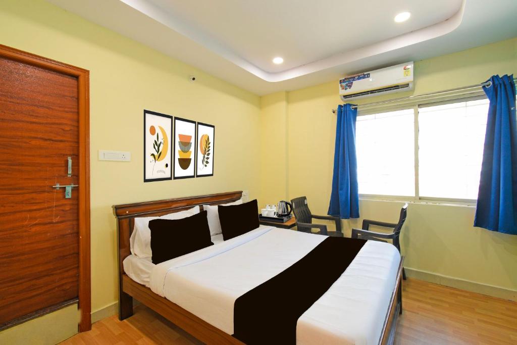 a bedroom with a bed and a desk and a window at HOTEL O MYRAA INN in Surūrnagar