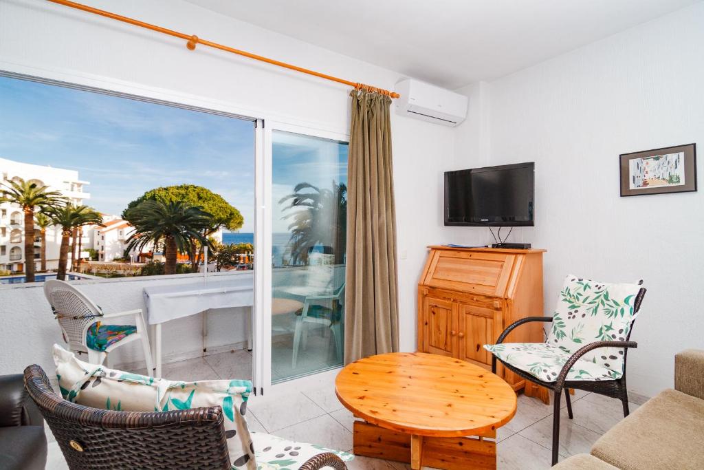a living room with a television and a table and chairs at Carabeo 16 Studios Casasol in Nerja