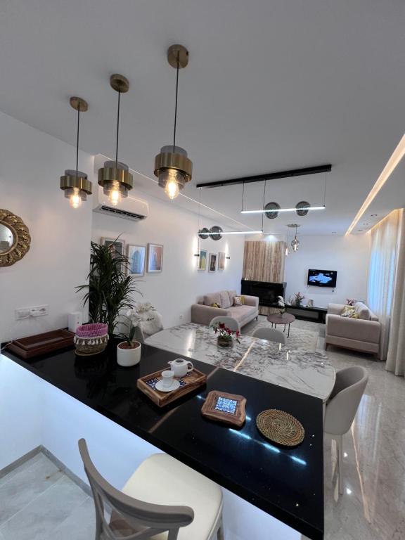 a kitchen and living room with a table and chairs at Résidences kenza in Kelibia