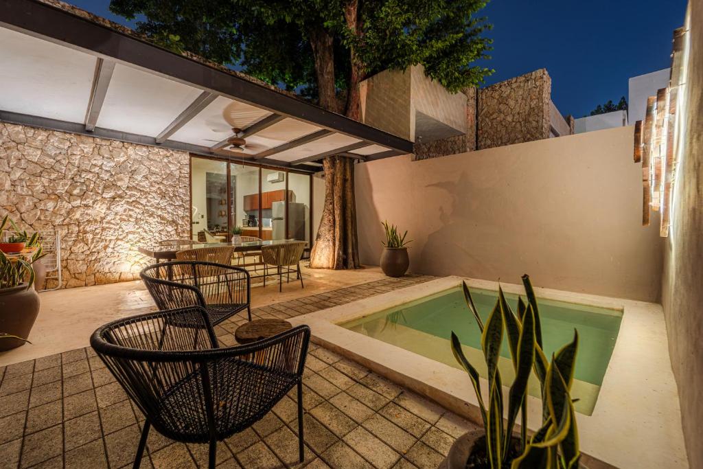 a patio with chairs and a swimming pool at Casa Balada Santa Lucía with Parking by Cercana in Mérida