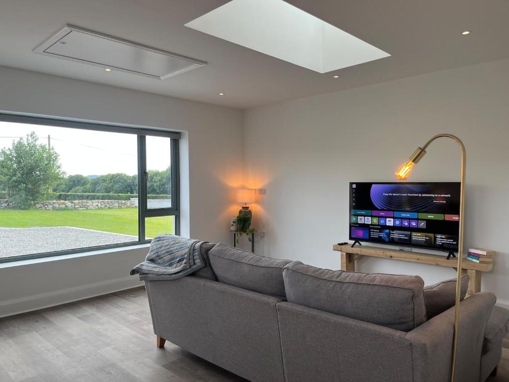 a living room with a couch and a flat screen tv at Little Hills in Westport