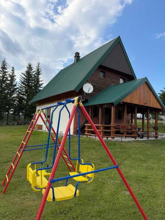 a playground in front of a log cabin at House in forest in Žabljak