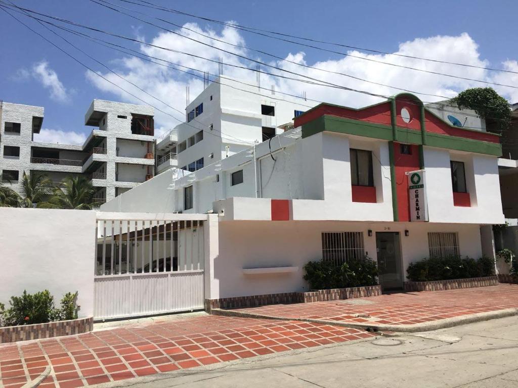 a white building with a red and white at Hotel Charmin in Gaira