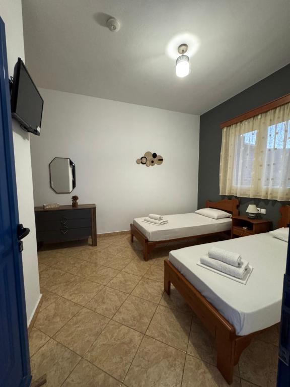 a room with two beds and a flat screen tv at Dream Catcher3 in Agia Theodoti
