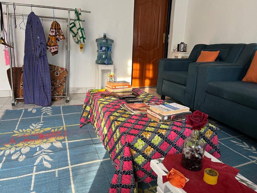 a living room with a couch and a table with books at Blue Home Stay in Janjagiro