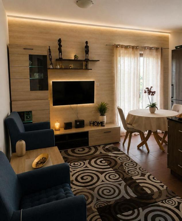 a living room with a television and a dining room table at Seaside Apartments - Vasilije in Baošići
