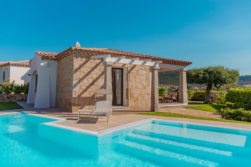 a villa with a swimming pool in front of a house at VILLA INDIPENDENTE AL MARE BUDONI in Tanaunella