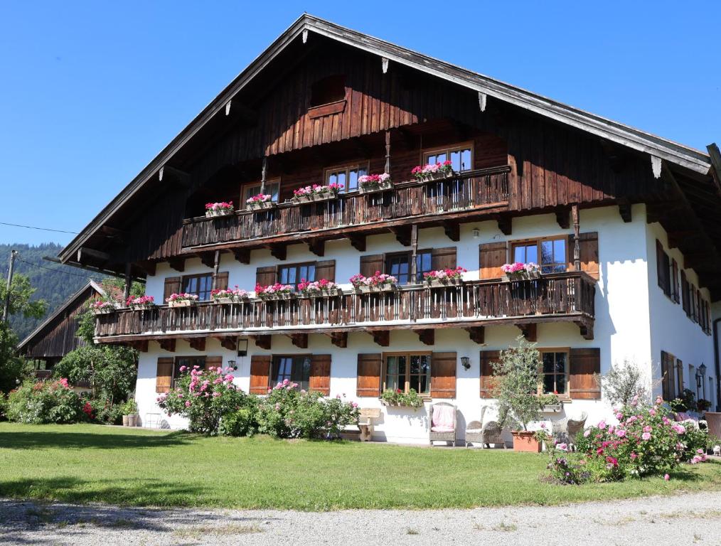 a building with a balcony with flowers on it at Ferienwohnungen Heissbauer in Wackersberg