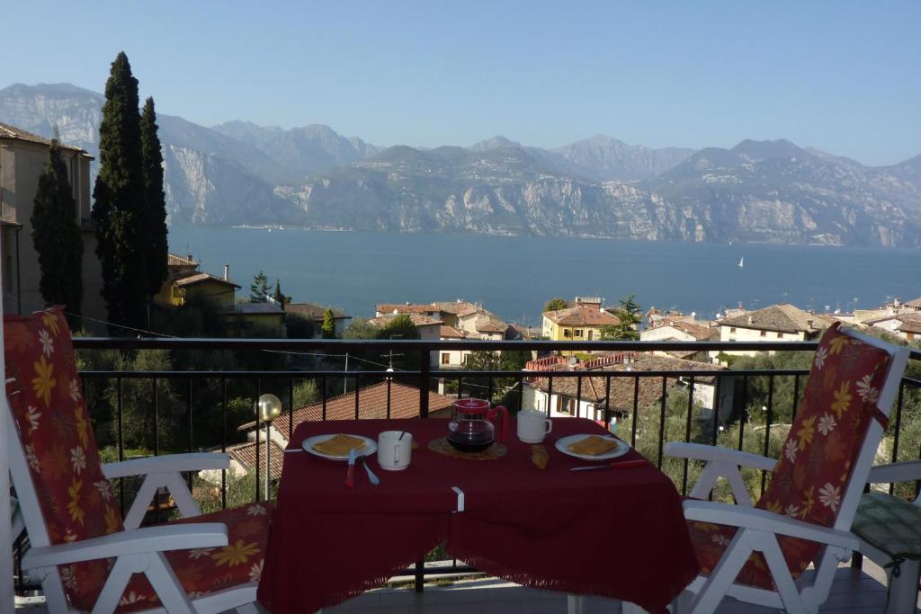 a table on a balcony with a view of the water at Piccolo Residence in Malcesine