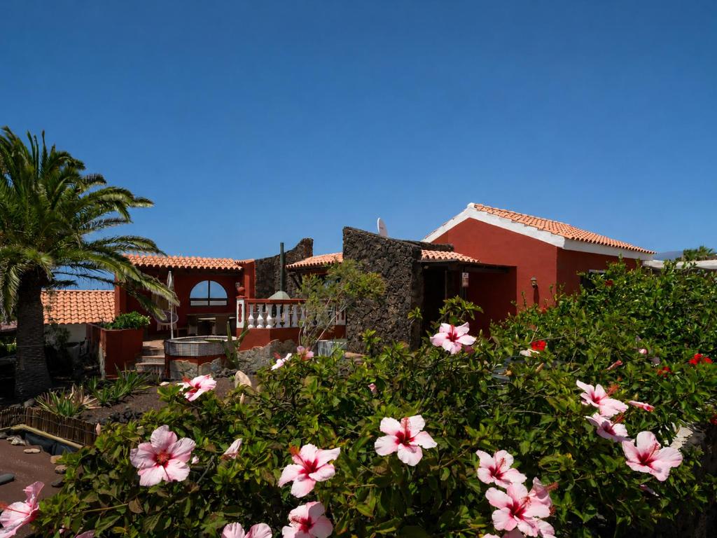 a house with pink flowers in front of it at Casa Zapato in La Pared
