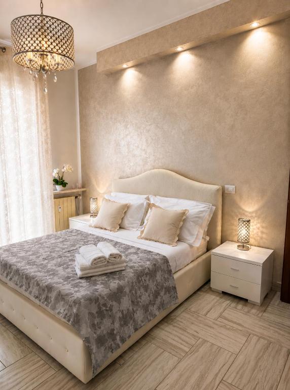 a bedroom with a large bed and a chandelier at Alloggio Acqui in Acqui Terme