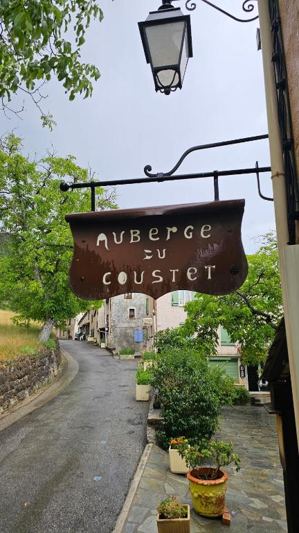 a sign hanging from the side of a building at Auberge du Coustet in Saint-Léger