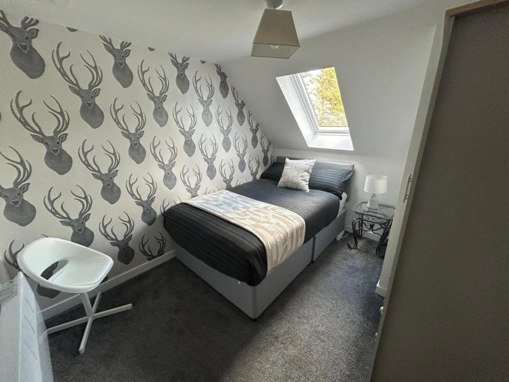 a small bedroom with a bed and a chair at Sleeps4-FamilyFriendly-FreeParking- Nc500 in Wick