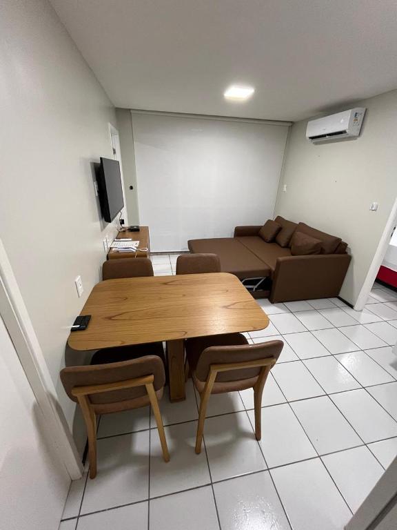 a living room with a wooden table and a couch at Gran Lençóis Flat Residence Barreirinhas in Barreirinhas