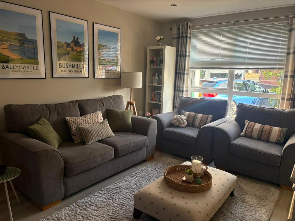 a living room with two couches and a table at Old Schoolhouse Coleraine in Coleraine