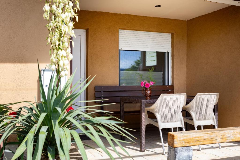 eine Terrasse mit Tisch, Stühlen und einer Pflanze in der Unterkunft Bobnarica in Grahovo