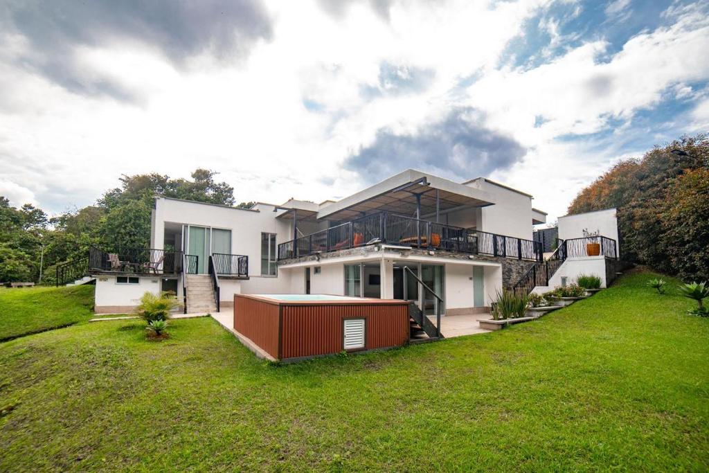 a large white house with a green yard at Casa campestre en el Eje Cafetero in Circasia