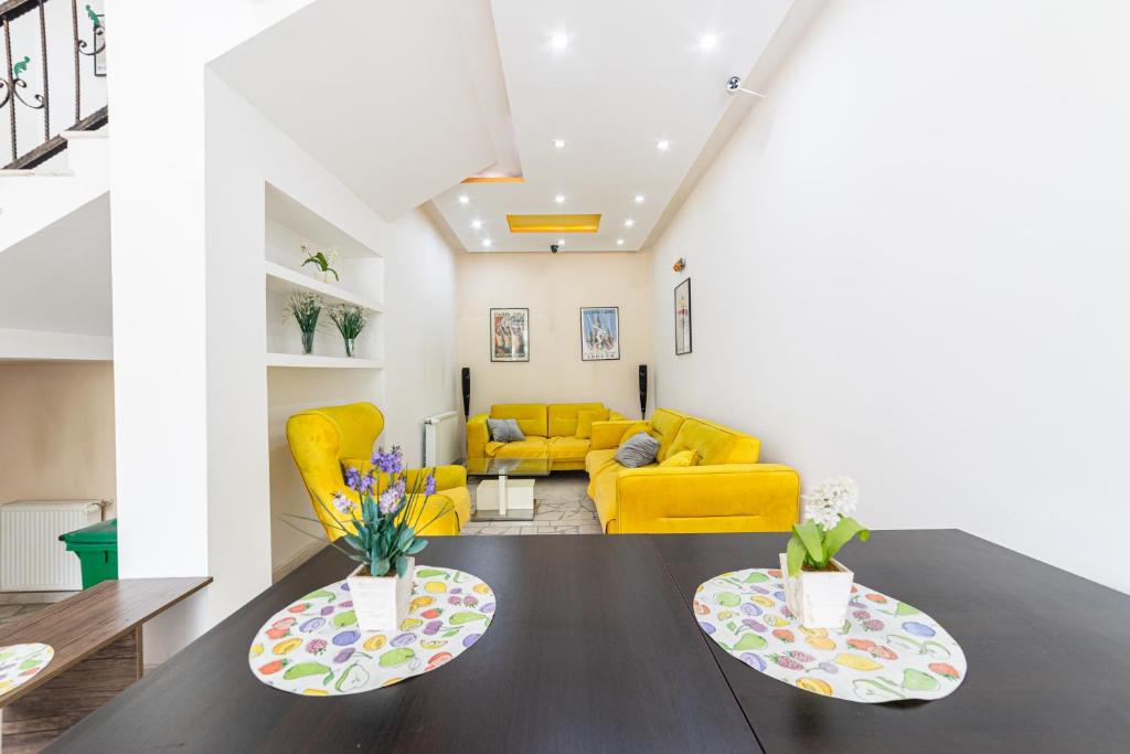 a living room with a table and a yellow couch at Aparthotel HayatHills in Sarajevo