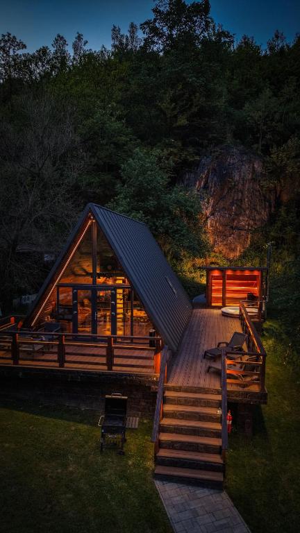 a large wooden cabin with a large roof at Valea Mosului - Cozy A Frame in Petroşani