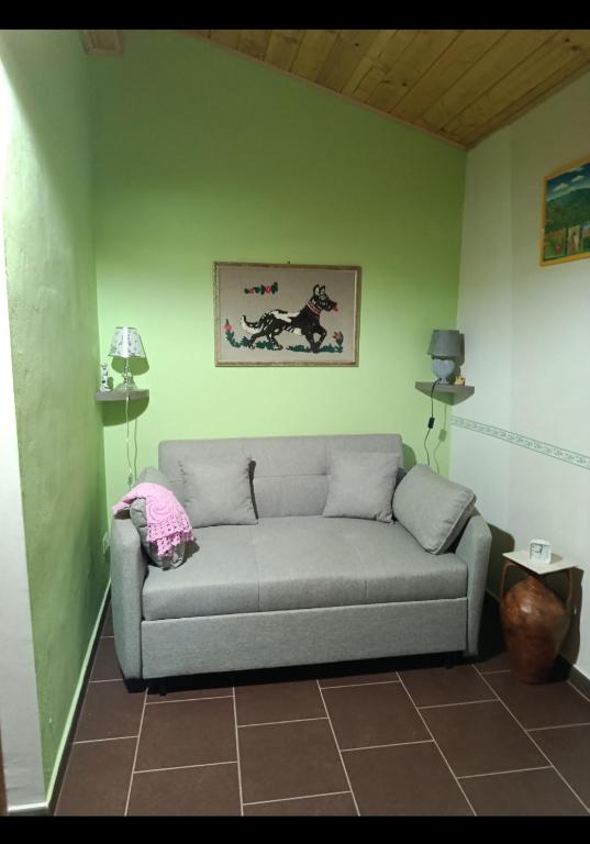 a couch in a room with a green wall at La casetta dei carciofi in San Fratello