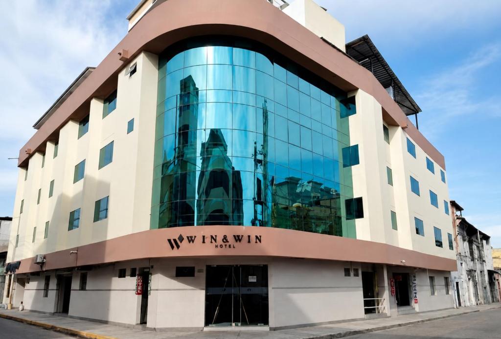 ein Gebäude mit Glasfassade an einer Straße in der Unterkunft Win & Win Hotel & Casino Piura in Piura