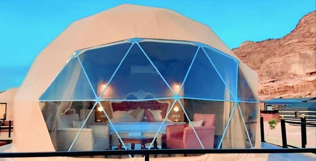 a dome house with a living room in the desert at Wadi Rum Elara Luxury Camp in Wadi Rum