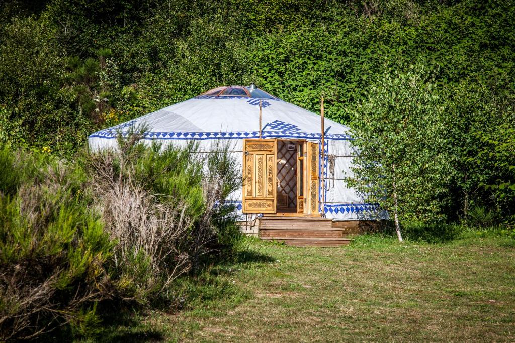 une yourte avec une porte en bois dans un champ dans l'établissement Domaine des Planesses, à Ferdrupt